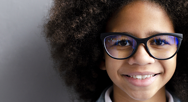 Smiling Black girl with glasses.